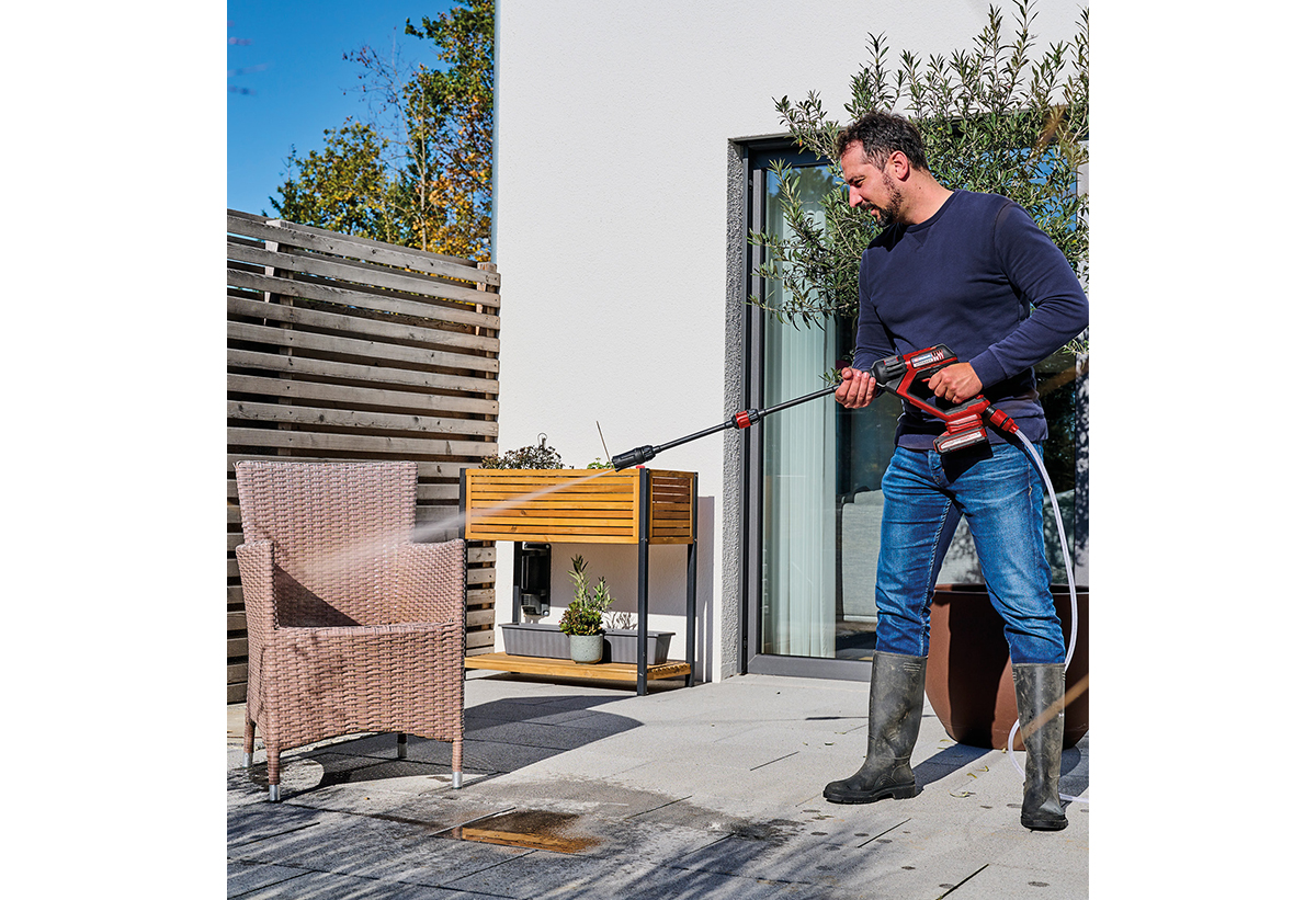 Απεικονίζεται άνδρας να χρησιμοποιεί το πλυστικό σε πολυθρόνα κήπου.